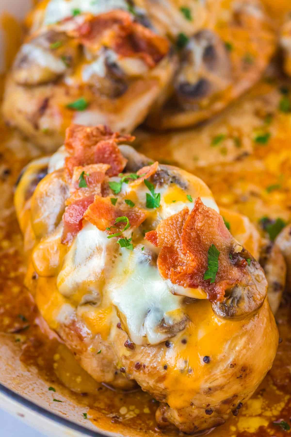 alice springs chicken with mushrooms bacon and cheese in a skillet.
