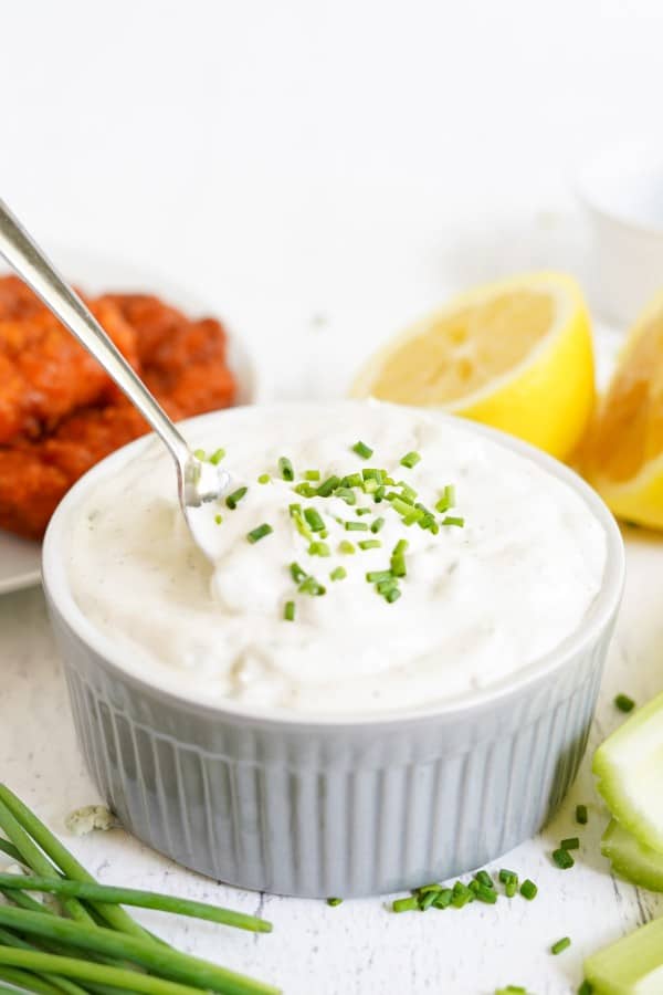 blue cheese dip in a white ramekin with a spoon.