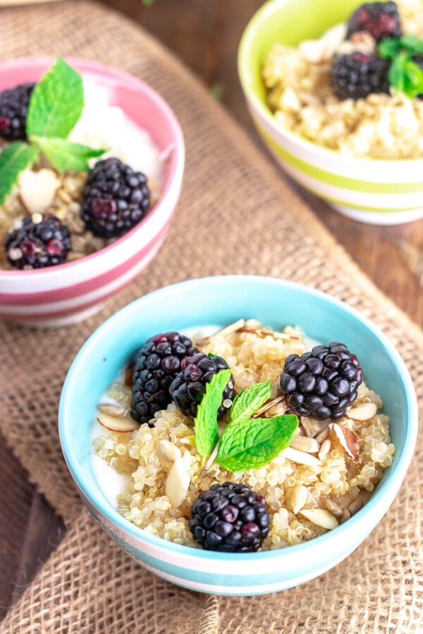 quinoa breakfast bowls with blackberries in colorful bowls
