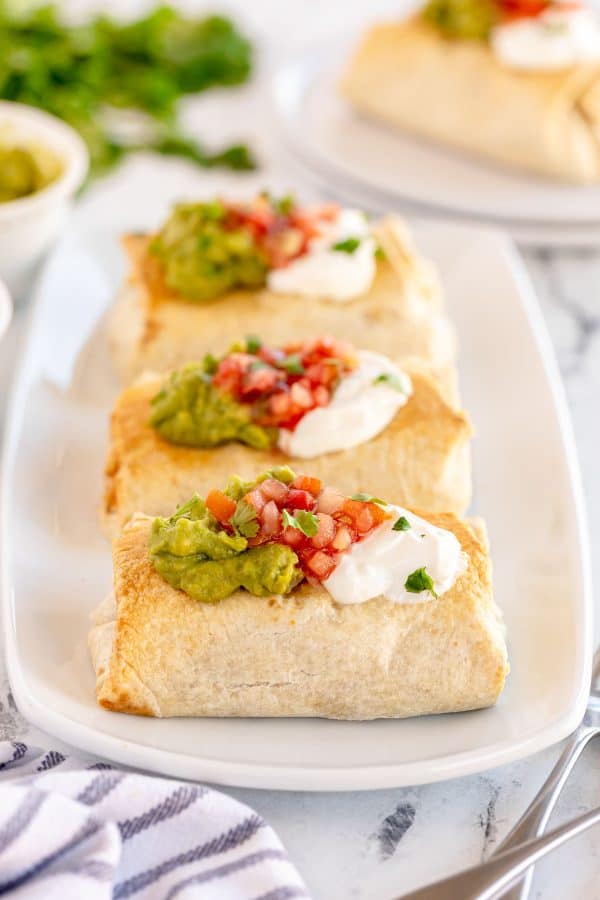 baked chicken chimichangas on a white plate.