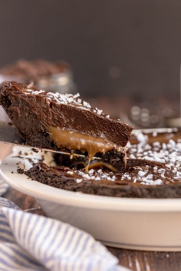 slice of chocolate tart being lifted out of a pie plate.