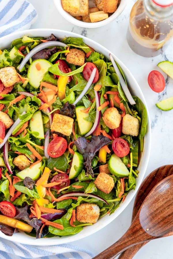 Garden salad with fresh vegetables and crunchy croutons, served in a clean white bowl.