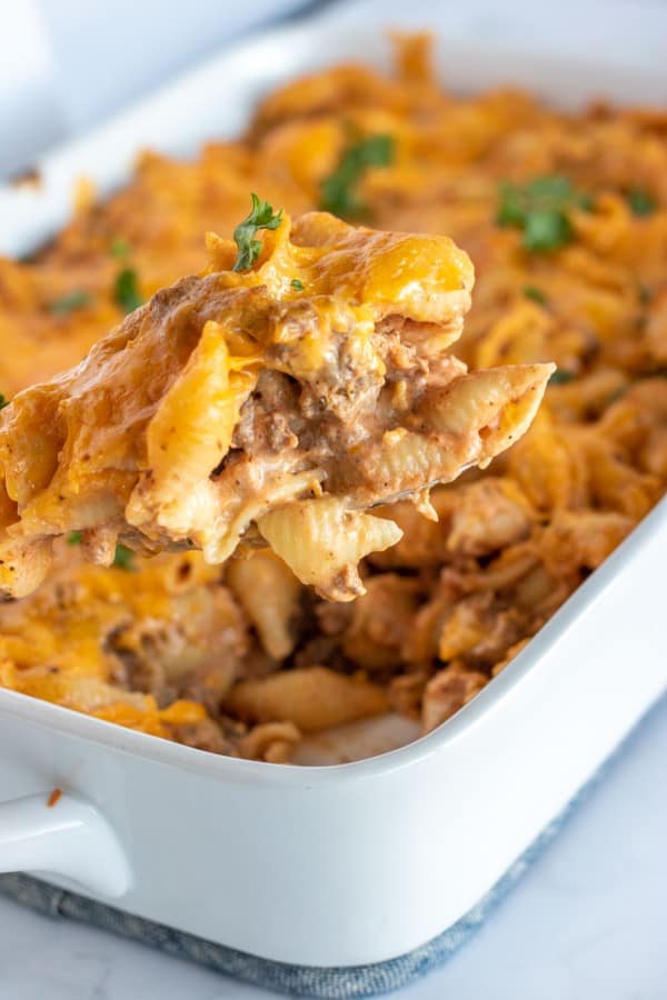 hamburger casserole in a white dish with a spoonful pulled out