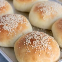 close up of hamburger buns on a metal baking sheet