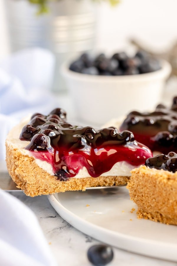 No bake cheesecake on a white plate with a platter of cheesecake
