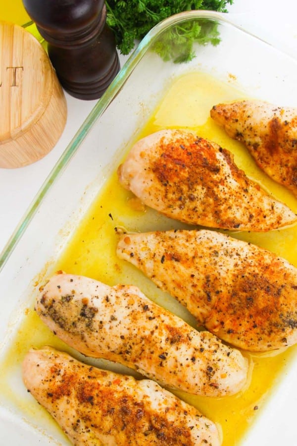 baked chicken breasts in a clear baking dish.