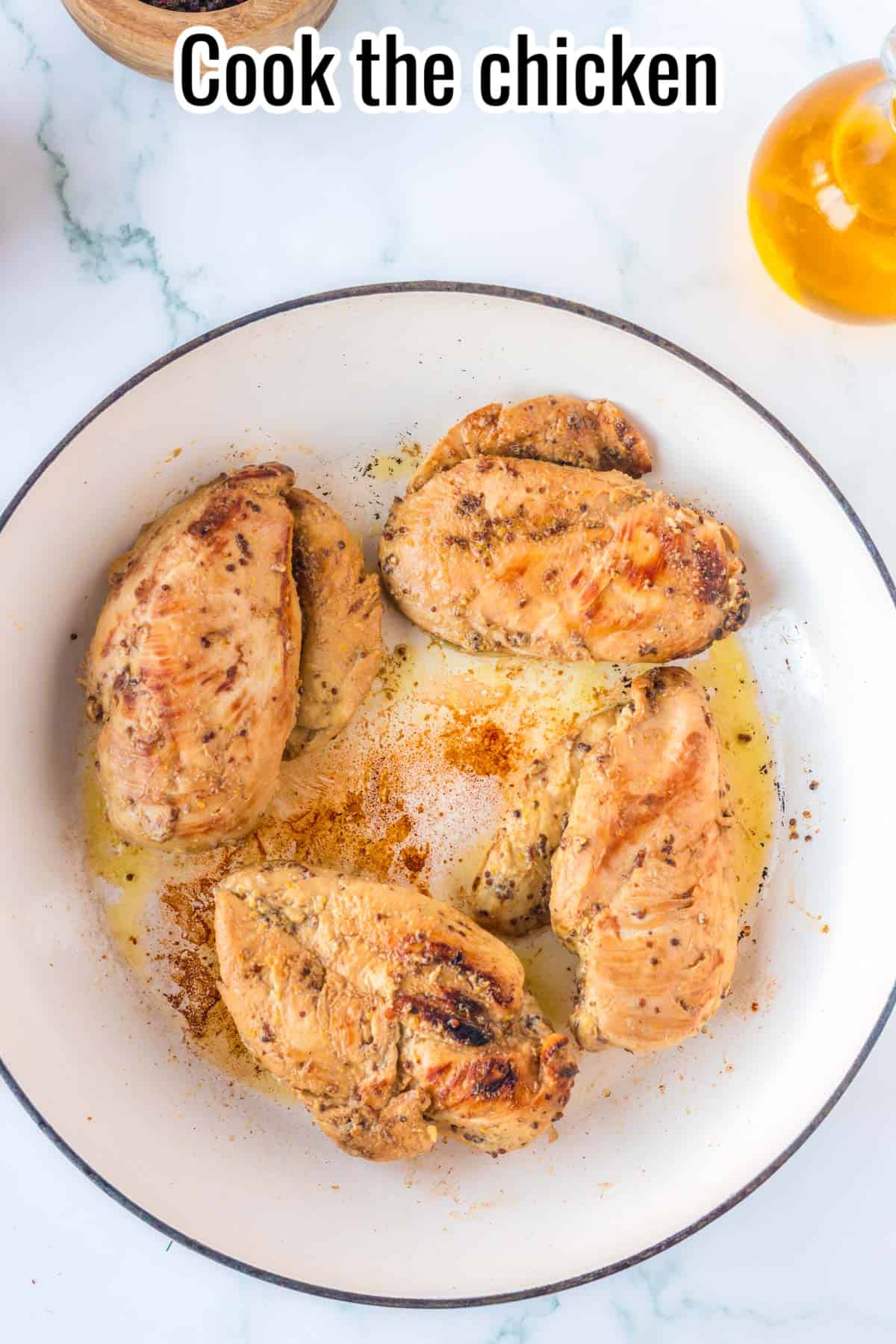 4 cooked chicken breasts in a skillet.