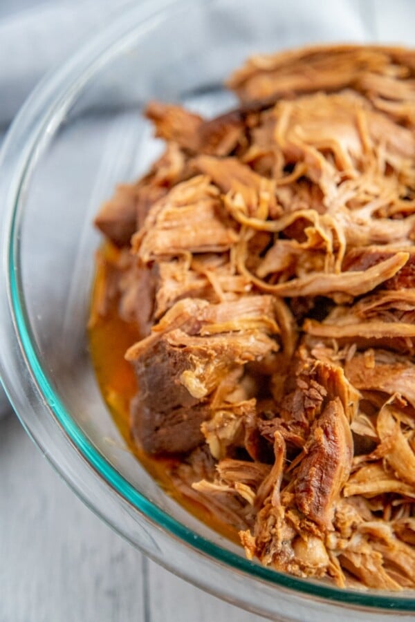 pulled pork in a glass bowl on a white background