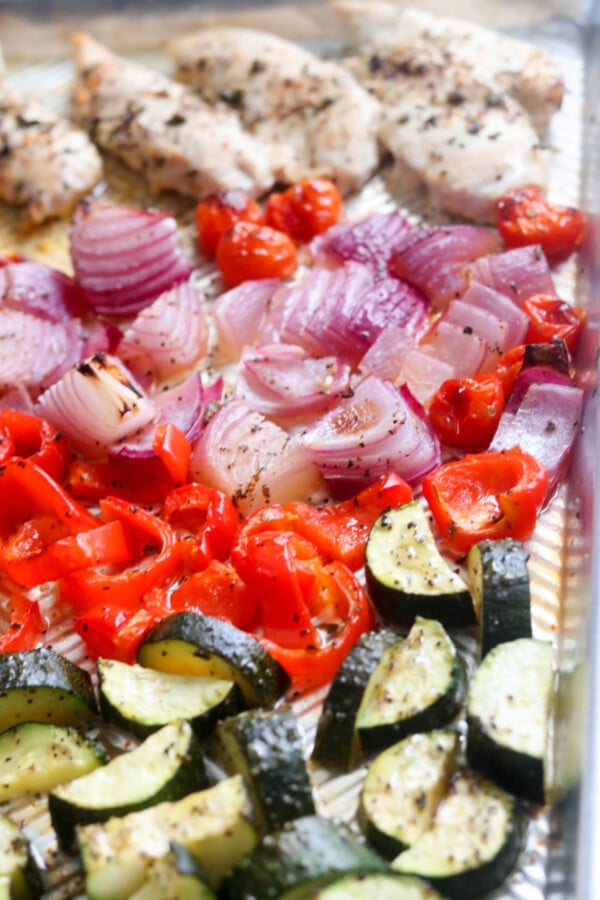 over head shot of cooked chicken and vegetables on a sheet pan