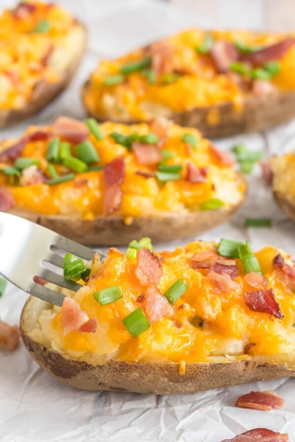 twice baked potato on a white plate with a fork