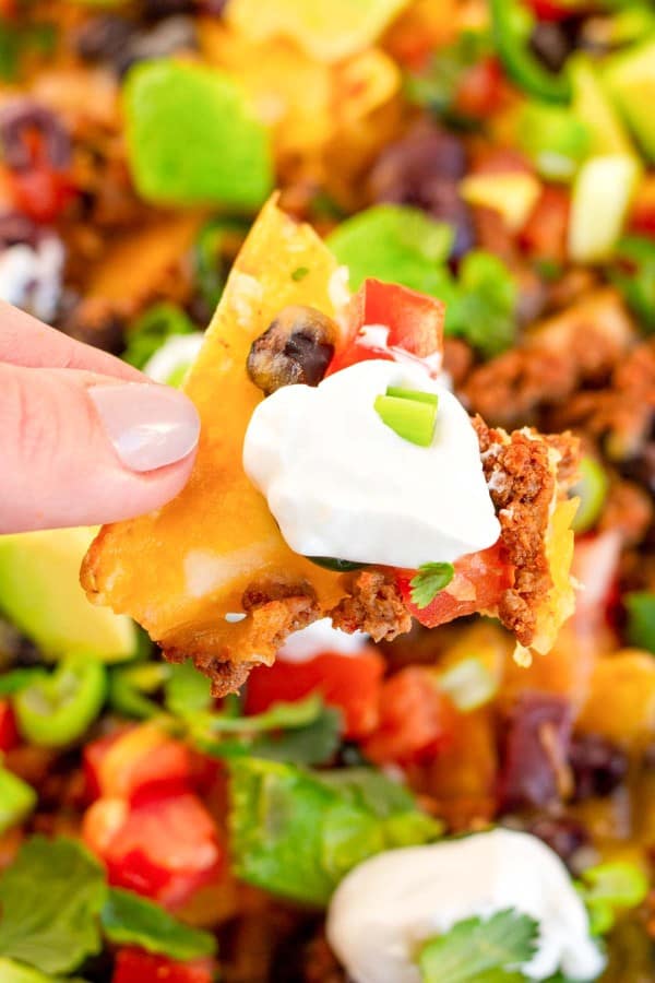 nachos being held by fingers.