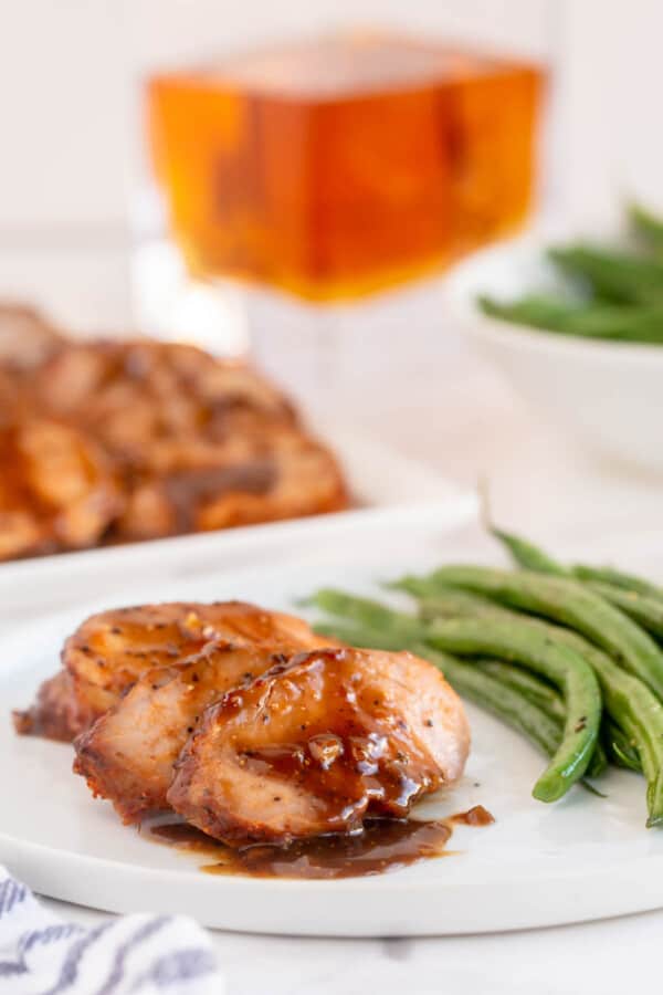 glazed pork tenderloin on a white plate with vegetables